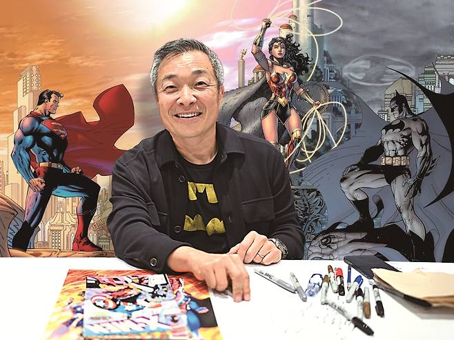 수퍼맨·배트맨·원더우먼…. 웬만한 수퍼히어로는 그의 손에서 다시 태어났다. 2024년 뉴욕 코믹콘 참석 당시 짐 리의 사진을 배경으로 짐 리의 대표작 표지를 합성했다. /게티이미지·DC코믹스