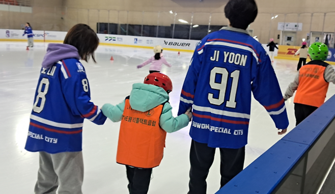 ▲ 수원시청 아이스하키팀 선수들이 아동들의 스케이트 체험을 돕고 있다.