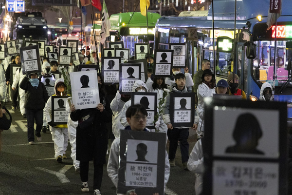 지난해 3월 6일 서울 중구 태평로 삼성본관 앞에서 반도체특별법 폐기 결의대회가 열렸다. 이날 시민들이 질병에 걸려 숨진 반도체 노동자들의 영정사진을 들고 행진에 참여하고 있다. / 반도체노동자의건강과인권지킴이 반올림