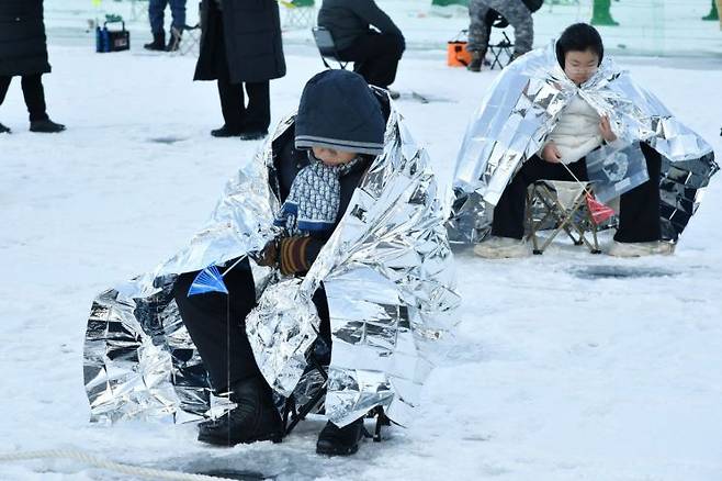 개막 이틀째인 11일 제설 작업이 깔끔하게 마무리된 화천산천어축제장에서 관광객들이 얼음낚시를 즐기고 있다. 화천군 제공
