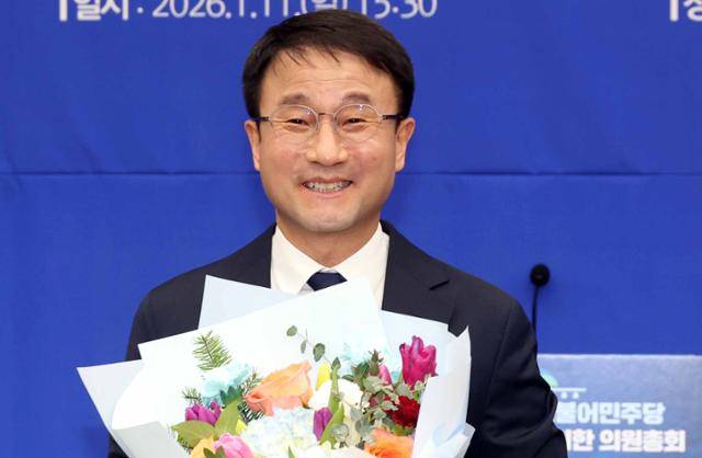 한병도 더불어민주당 신임 원내대표가 11일 국회에서 열린 민주당 제2기 원내대표 선출 의원총회에서 꽃다발을 들고 미소 짓고 있다. 뉴시스