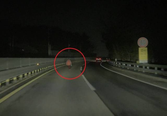 This photo, provided by the Army's 22nd Infantry Division to the local media, shows a senior woman with dementia walking in the middle of a highway. (The 22nd Infantry Division)