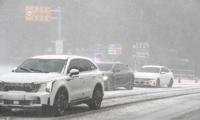 제주 산지·중산간·동부·남부에 대설특보가 내려진 11일 제주시 어승생 삼거리 입구에서 제주서부경찰서 소속 경찰관이 도로통제를 하고 있다. 뉴시스