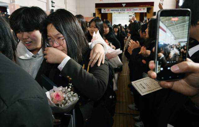 9일 창원시 진해구 진해여자중학교 체육관에서 열린 마지막 졸업식에서 졸업생들이 1·2학년 재학생들의 환송을 받으며 학교를 나서고 있다. /김승권 기자/