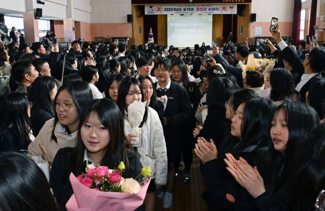 9일 창원시 진해구 진해여자중학교 체육관에서 열린 마지막 졸업식에서 졸업생들이 1·2학년 재학생들의 환송을 받으며 학교를 나서고 있다. /김승권 기자/