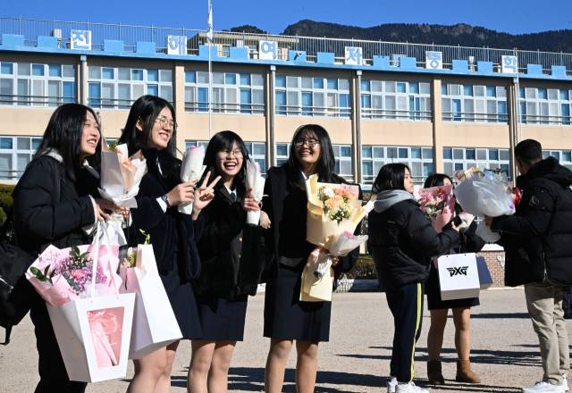 9일 창원시 진해구 진해여자중학교 마지막 졸업식에서 졸업생들이 교정을 배경으로 기념사진을 남기고 있다. /김승권 기자/