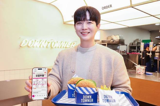 LG유플러스 모델이 유플투쁠 제휴처 다운타우너에서 1월 대표 혜택인 버거세트를 소개하고 있다. LG유플러스 제공