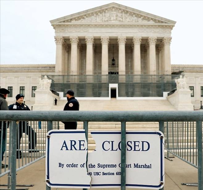 < 상호관세 운명은…> 지난 9일 미국 워싱턴DC 연방대법원 앞에 법원 경찰들이 배치돼 있다. 미 연방대법원은 이르면 오는 14일 상호관세가 적법한지 여부를 판결할 것으로 예상된다.   로이터연합뉴스