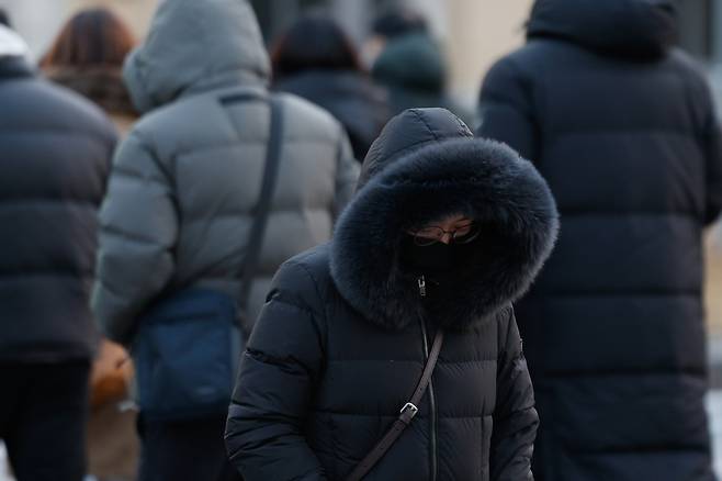 Commuters hurry to work at the Gwanghwamun intersection in Jongno District, central Seoul on Jan. 12. [NEWS1]