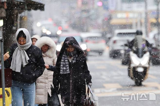 [서울=뉴시스] 권창회 기자 = 서울·인천·경기 서해안에 눈이나 비가 예보된 12일 서울 송파구 주택가에서 시민들이 눈을 맞으며 이동하고 있다. 2025.01.12. kch0523@newsis.com