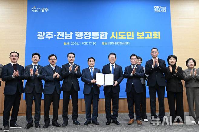 [광주=뉴시스] 이영주 기자 = 강기정(가운데 왼쪽) 광주시장과 김영록(가운데 오른쪽) 전남도지사를 비롯한 광주시·전남도 공직자들이 9일 오후 광주 서구 김대중컨벤션센터에서 열린 광주·전남 행정통합 시도민 보고회에 참석해 공동발표문을 들고 기념사진을 촬영하고 있다. 2026.01.09. leeyj2578@newsis.com