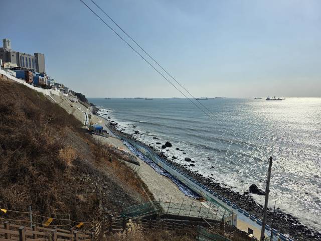 부산 영도의 해안 절경을 바라보며 산책할 수 있는 흰여울문화마을 해안산책로 경사지 공사 완공이 두 차례 연기됐다. 바닷가에 일직선으로 뻗은 해안산책로가 통제돼 있는 모습. 김재량 기자 ryang@