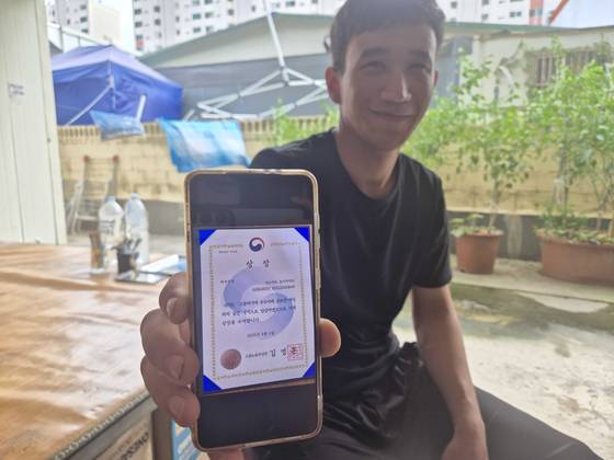 고용허가제(E-9)로 2년 전 입국한 우즈베키스탄 국적 아바르 호지악바르(28)가 '고용허가제 우수사례 공모전' 최우수상 상장 사진을 보여주고 있다. 전율 기자