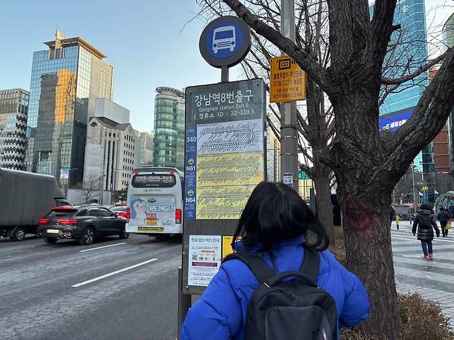 Lee Mi-young waits for a village bus for her commute at the Gangnam Station Exit 8 bus stop on the morning of Jan. 13. [RYU HYO-RIM]