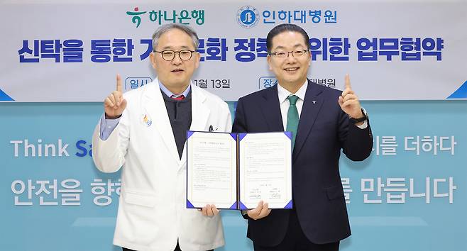 이호성 하나은행장(오른쪽)이 이택 인하대병원장 겸 의료원장과 협약서를 들고 기념촬영을 하고 있다.사진제공=하나은행
