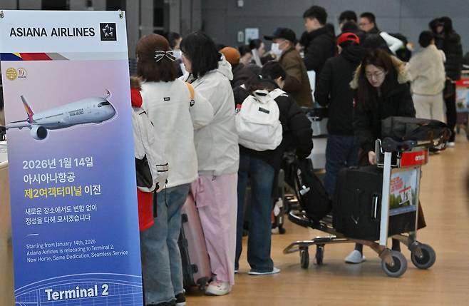 아시아나항공이 인천국제공항 제2터미널로 이전 운항을 개시한 14일 오전 인천국제공항 2터미널 아시아나항공 체크인 카운터에서 승객들이 탑승 수속을 밟고 있다. 연합뉴스