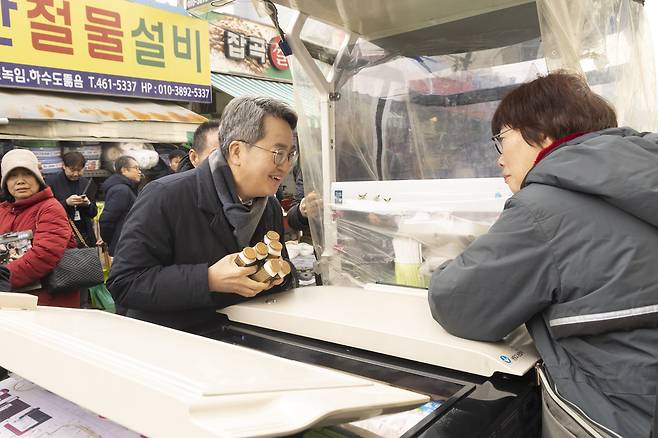 15일 오후 김동연 경기지사가 경기도 지원으로 폭설 피해 복구 작업이 진행 중인 의왕 도깨비시장을 방문해 상인들과 인사를 하고 있다.