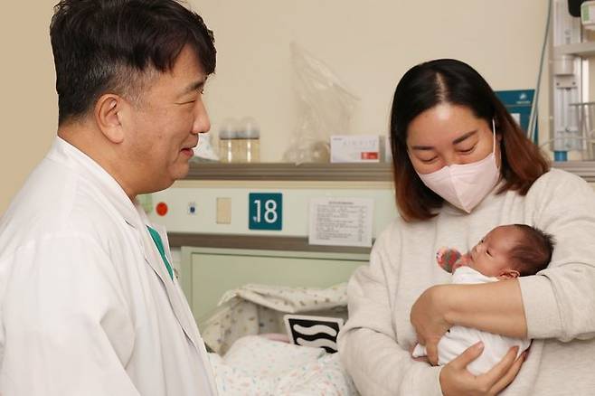 서울아산병원은 심장 크기가 엄지손가락만한 저체중아의 복잡한 선천성심장병을 생후 8일 만에 치료하는 데 성공했다. 사진은 수술을 집도한 윤태진 서울아산병원 소아심장외과 교수(왼쪽)와 퇴원을 앞둔 이준이 어머니와 이준이의 모습. ⓒ서울아산병원