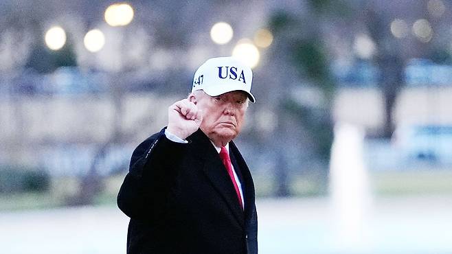 ‘USA(미국)’가 새겨진 흰 모자를 쓴 도널드 트럼프 미국 대통령이 13일(현지시간) 워싱턴 DC 백악관에서 취재진을 향해 오른손 주먹을 들어 보이며 인사하고 있다. AP=연합뉴스