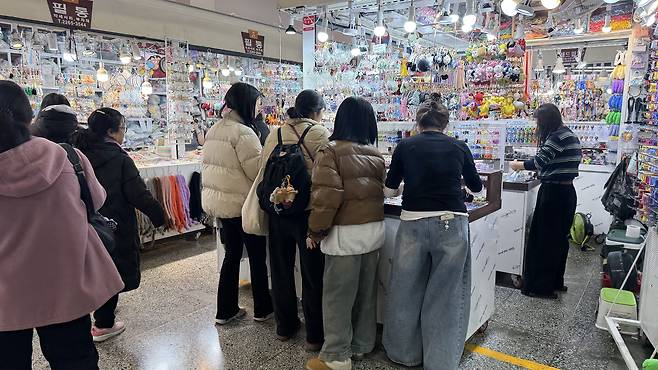 Shoppers carefully select charms to customize their pens at a store known for pen customization. [WOO JI-WON]