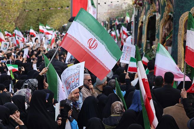 Iranians wave national flags during the funerals of more than 100 security forces personnel killed in recent protests in Tehran on Jan. 14. [AFP/YONHAP]