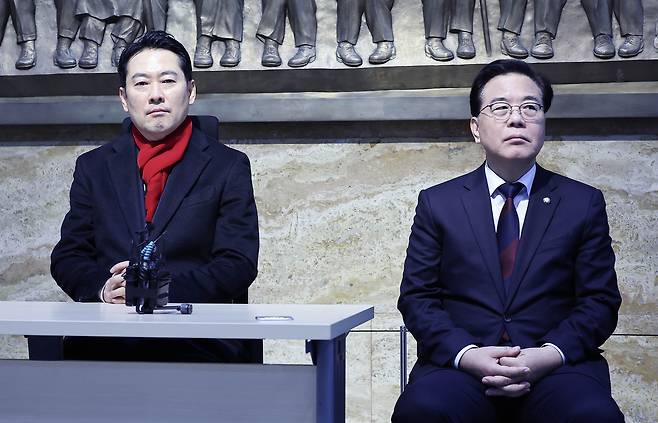 People Power Party (PPP) leader Jang Dong-hyeok, left, stages a hunger strike in the main rotunda of the National Assembly in western Seoul on the morning of Jan. 15, urging the Democratic Party to accept the “twin special counsel bills” on alleged political lobbying by the Unification Church and scandals involving paying for nominations. At his right is PPP floor leader Song Eon-seog. [LIM HYUN-DONG]