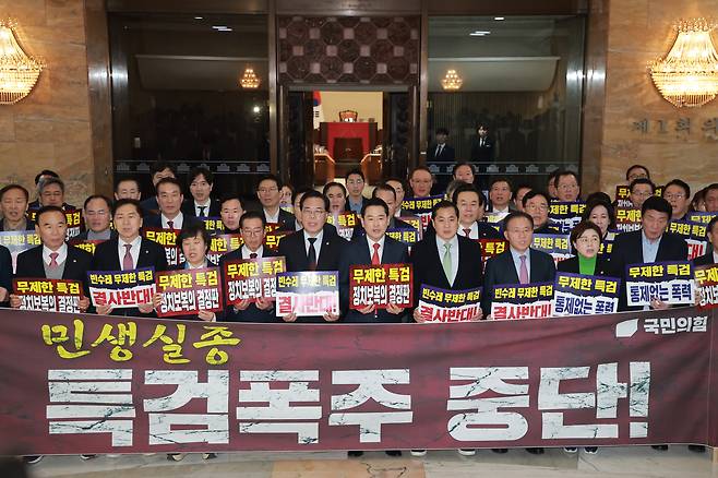 People Power Party leader Jang Dong-hyeok, sixth from the left in the front row; floor leader Song Eon-seog, fifth from the left in the front row; and other lawmakers hold a rally in the main rotunda of the National Assembly in western Seoul on Jan. 15, ahead of a plenary session, to protest the Democratic Party’s push to pass a second comprehensive special counsel bill. [YONHAP]