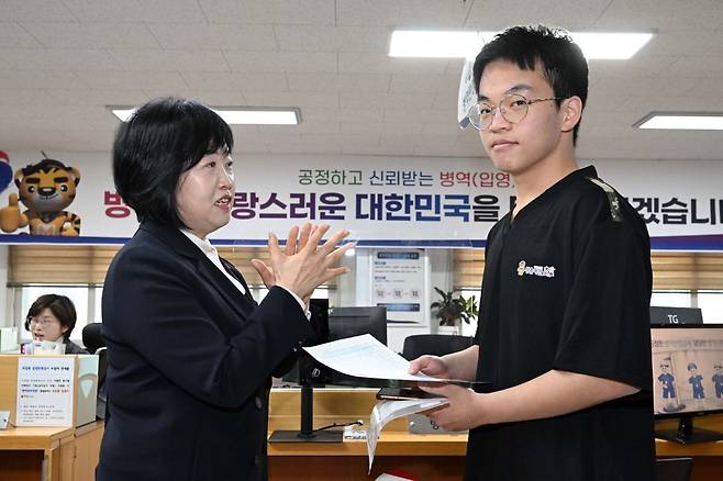 홍소영 병무청장이 15일 오전 서울 영등포구 서울지방병무청 제1병역판정검사장에서 열린 2026년도 병역판정검사에서 첫 현역 판정자를 축하해주고 있다. 뉴시스