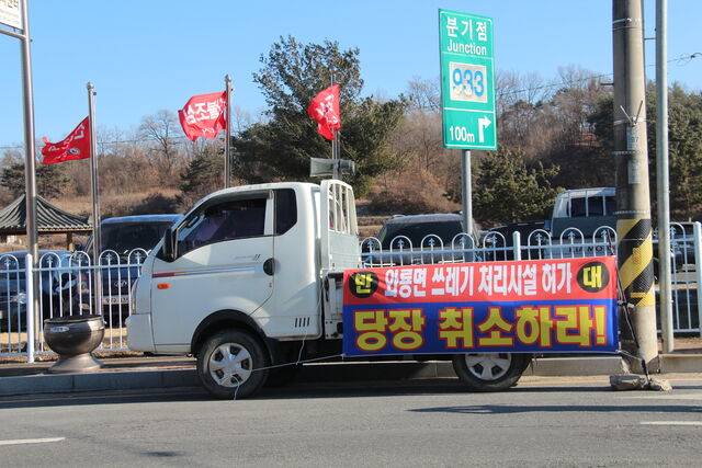 경북 안동시 와룡면의 한 도로에 주차된 트럭. 화물칸에 폐플라스틱 처리공장 허가를 취소하라고 적힌 현수막이 달려있다.
