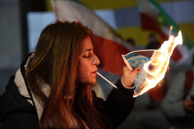 14일(현지시간) 이스라엘 홀론에서 한 이스라엘·이란 공동체 구성원이 이란에서 지속되는 반정부 시위대를 지지하는 시위에 참석해 이란 최고 지도자 알리 하메네이의 사진을 불태우고 있다. 2026.1.14 EPA 연합뉴스