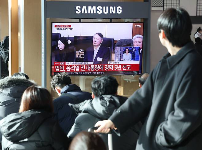 16일 서울역 대합실에서 시민들이 고위공직자범죄수사처(공수처) 체포방해 등 혐의로 기소된 윤석열 전 대통령에 대한 1심 선고 공판 생중계를 보고 있다. 연합뉴스