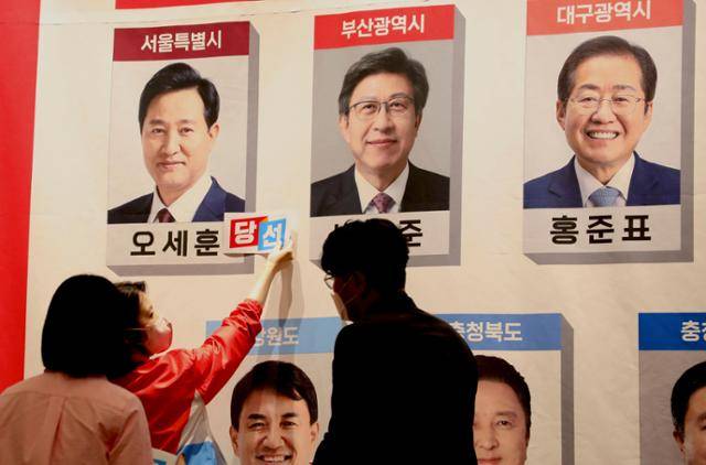 국민의힘 당직자가 2022년 6월 1일 서울 국회도서관 대회의실에 차려진 제18회 전국동시지방선거 개표상황실에서 당선자 사진에 스티커를 붙이고 있다. 오대근 기자