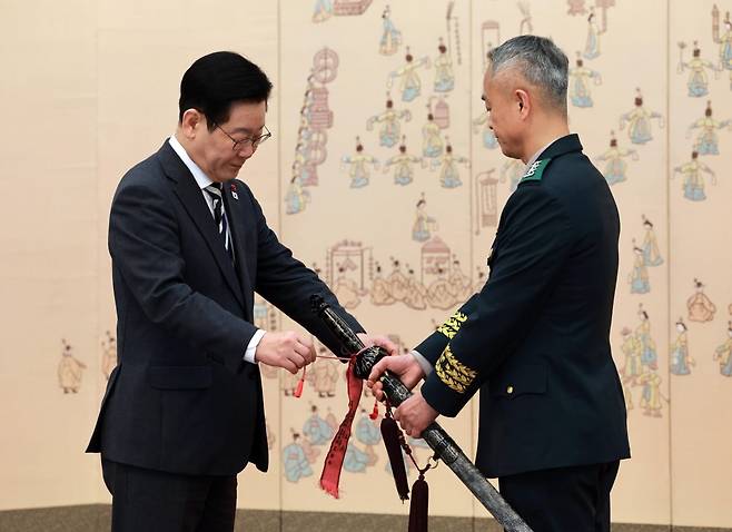 이재명 대통령이16일 청와대 본관에서 열린 3성 장군 진급·보직 신고 및 수치 수여식에서 어창준 수도방위사령관의 삼정검에 수치를 달아주고 있다. 사진=뉴스1