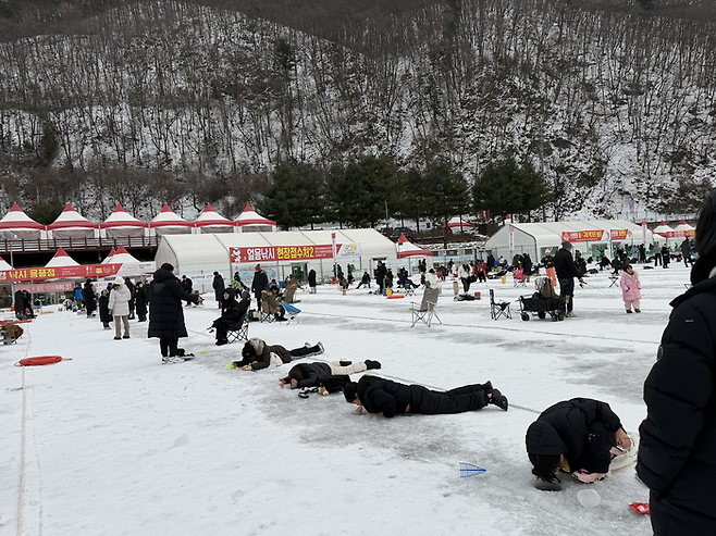 구멍 속으로 산천어를 보는 사람들 / 사진= 문서연 여행+ 기자