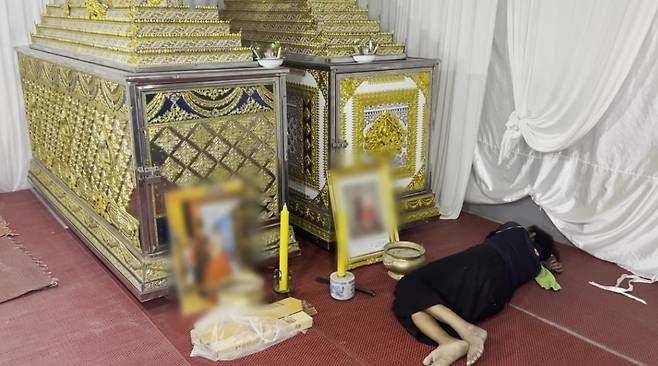 딸과 한국인 사위 관 앞에서 슬픔에 잠겨 누워있는 60대 태국인 여성. /MCOT