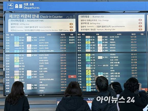 아시아나항공의 인천공항 제2터미널 이전 이후 첫 주말인 17일, 출국객들이 체크인 카운터 인근에서 안내 전광판을 확인하고 있다. [사진=권서아 기자]