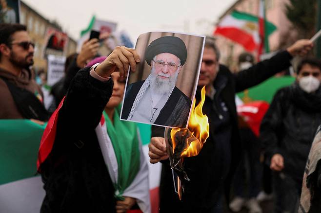 17일(현지시간) 이탈리아 밀라노에서 이란 반정부 시위를 지지하기 위해 열린 집회에서 한 시민이 이란 최고지도자 아야톨라 알리 하메네이의 사진에 불을 붙이고 있다. 로이터연합뉴스