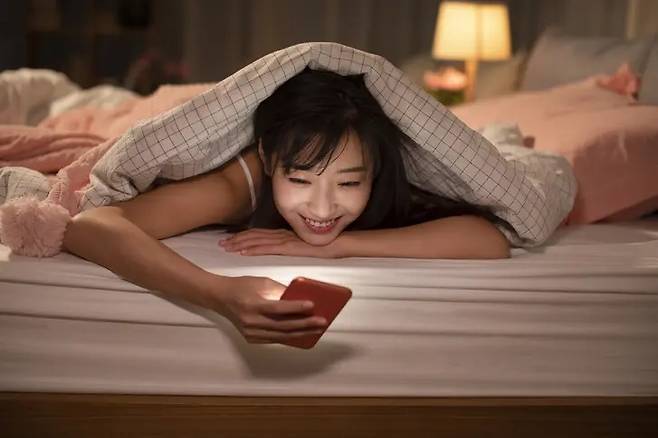 침대에 누워 스마트폰을 사용하는 모습은 흔한 일상이지만, 반복될 경우 안압 상승과 망막 손상으로 이어질 수 있다는 지적이 나온다. 의료진은 주변 조명을 켜고 사용 시간을 줄이는 것부터 실천하라고 조언한다. 게티이미지