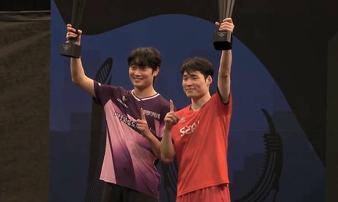 한국 탁구 대표팀의 장우진(오른쪽)과 조대성이 18일 카타르 도하에서 열린 WTT 스타 컨텐더 도하 2026 남자복식에서 우승을 차지한 뒤 시상식에서 트로피를 들고 기뻐하고 있다. 중계화면 캡처