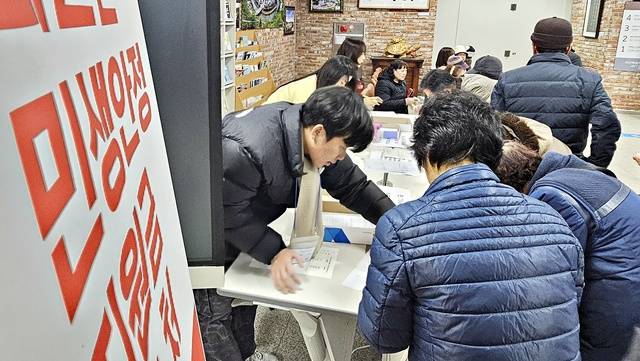 ▲ 괴산군 민생안정지원금 신청 첫날인 19일 괴산읍사무소 민원실 접수처를 찾은 군민들이 신청서를 작성하고 있다. /강신욱기자