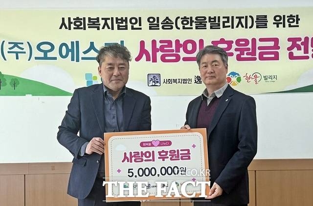 신요섭 한울빌리지 원장이 지난 16일 이상윤 OSP 상무에게 500만 원의 후원금을 받고 있다. /OSP 제공