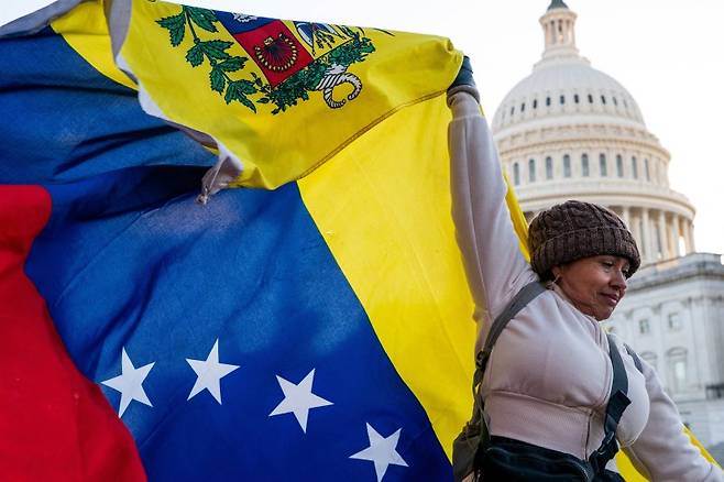 15일(현지시간) 미국 워싱턴DC 국회의사당 앞에서 한 시위대가 베네수엘라 국기를 흔들고 있다.로이터연합뉴스