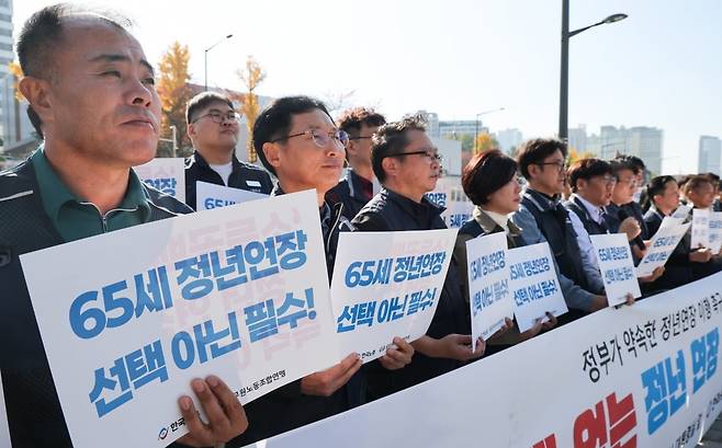 한국노총과 공무원노동조합연맹 관계자들이 12일 서울 용산구 전쟁기념관 앞에서 기자회견을 열고 정년연장 이행을 촉구하고 있다. 2025.11.12