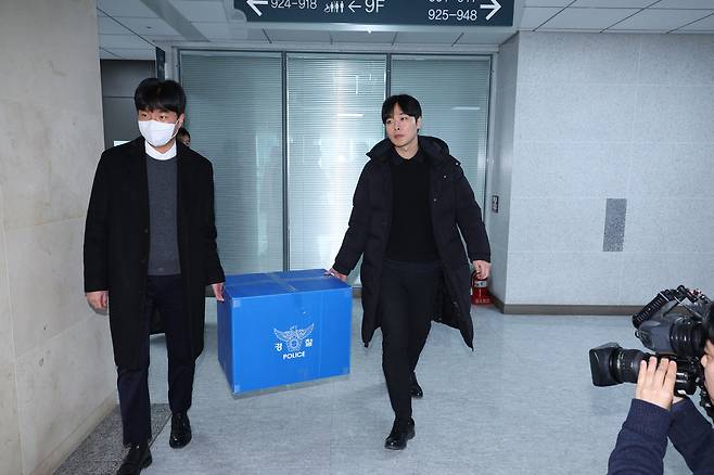 Investigators from the Public Crimes Investigation Division of the Seoul Metropolitan Police Agency’s Metropolitan Investigation Unit carry seized materials after completing a search and seizure of the office of Rep. Kim Byung-kee, a former floor leader of the Democratic Party, at the National Assembly Members’ Office Building in Yeouido, Seoul, on Jan. 14. [NEWS1]