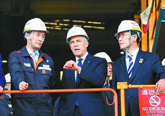 Hanwha Group Vice Chairman Kim Dong-kwan, left, Prime Minister of Canada Mark Carney, center, and Prime Minister Kim Min-seok are seen during a visit to Hanwha Ocean's Geoje shipyard in Geoje, South Gyeongsang, on Oct. 30, 2025. [YONHAP]