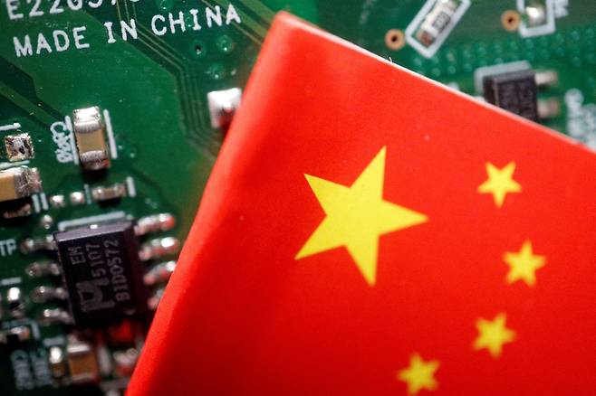 A Chinese flag is displayed next to ″Made in China″ marking on a printed circuit board in this illustration from Feb. 17, 2023. [REUTERS/YONHAP]