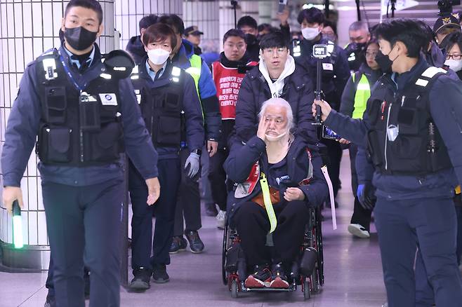 Park Kyung-seok, head of the Solidarity Against Disability Discrimination (SADD), is escorted out of City Hall Station in central Seoul on Nov. 30, 2023. [YONHAP]