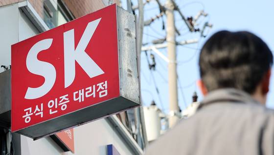A pedestrian walks by an SK Telecom shop in Seoul on Nov. 4. [NEWS1]