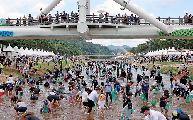 지난해 9월 열린 ‘2025 괴산고추축제’를 찾은 사람들이 동진천에서 물고기 잡기 체험을 즐기고 있다. 나흘간 열린 축제에는 31만 1000여명이 방문했다. 괴산군 제공