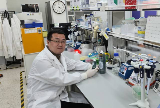 최식원 국립산림과학원 박사가 보리밥나무 추출물을 이용해 만든 탈모 치료·예방 제품을 살펴보고 있다. 사진 제공=국립산림과학원